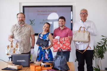 Das Team des Leihamts mit Handtaschen, die bei einem Workshop fachlich bewertet wurden