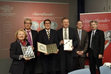 Rackwitz im Kreise weiterer Personen bei der Präsentation der Medaillensuite