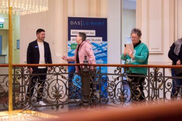 Begrüßung der Gäste zur Goldenen Stunde im historischen Leihamts-Gebäude vor der Kulisse des prunkvollen Kronleuchters